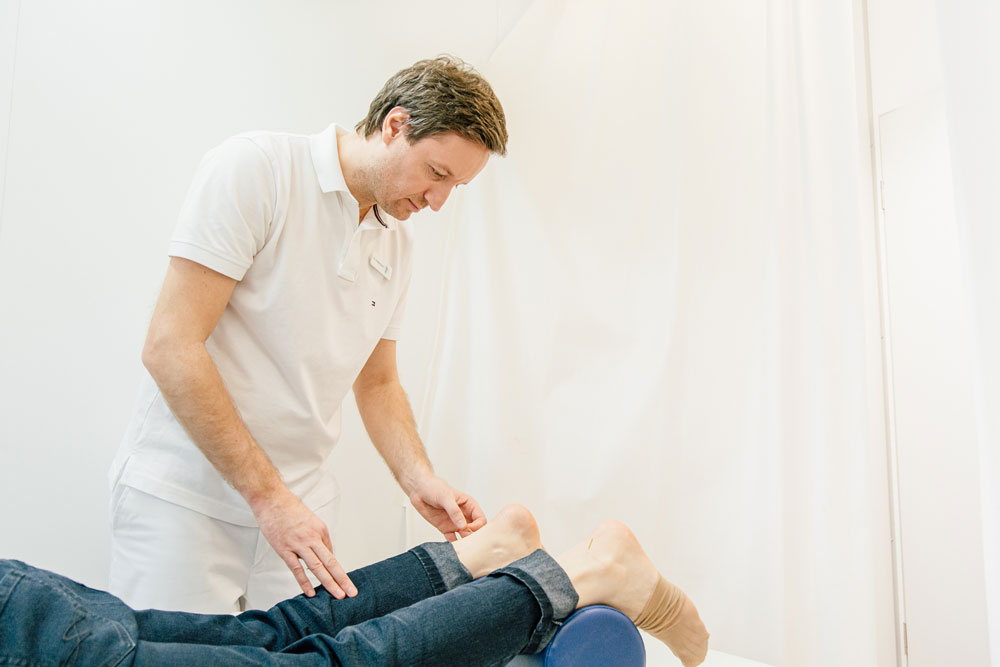 Akupunktur Bensberg - Dr. Reitenbach setzt feine Nadeln am Fuß einer Patientin